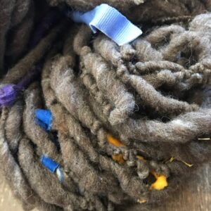 Corriedale and calico  – Natural brown yarn with cotton scraps, 100 yards
