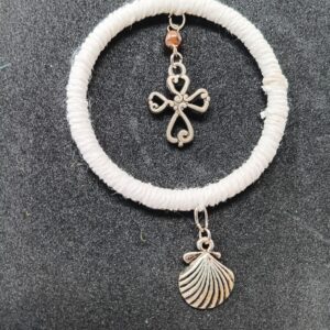 Small silver colored cross with scallop shell