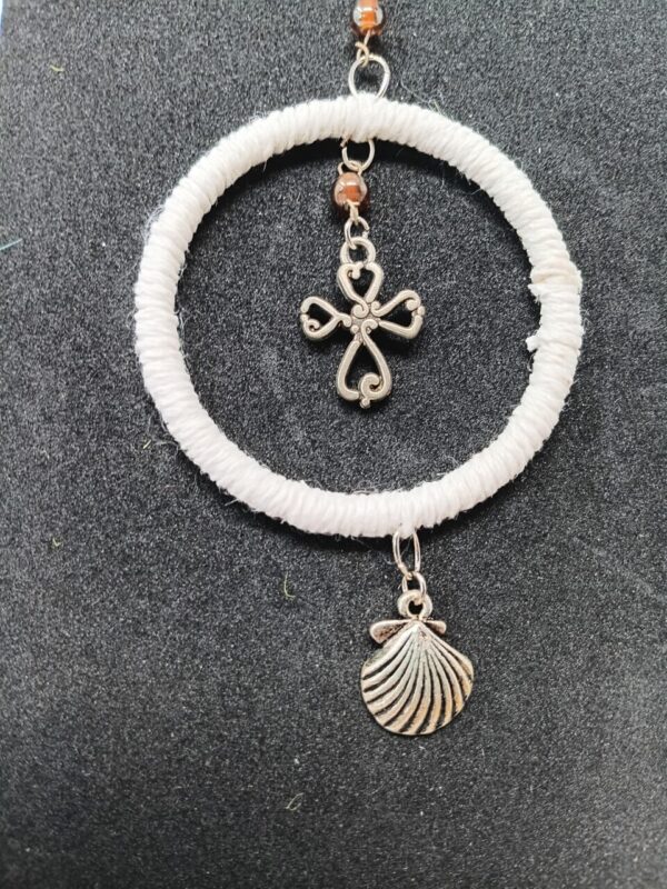 Small silver colored cross with scallop shell